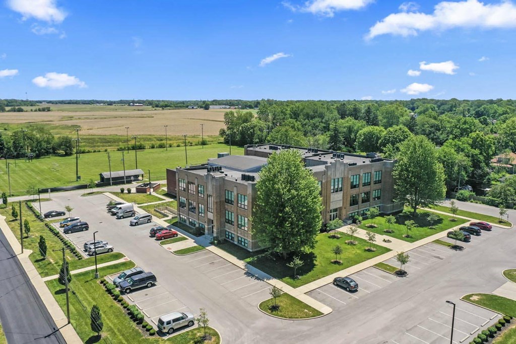 an aerial view of an apartment building next to a parking lot