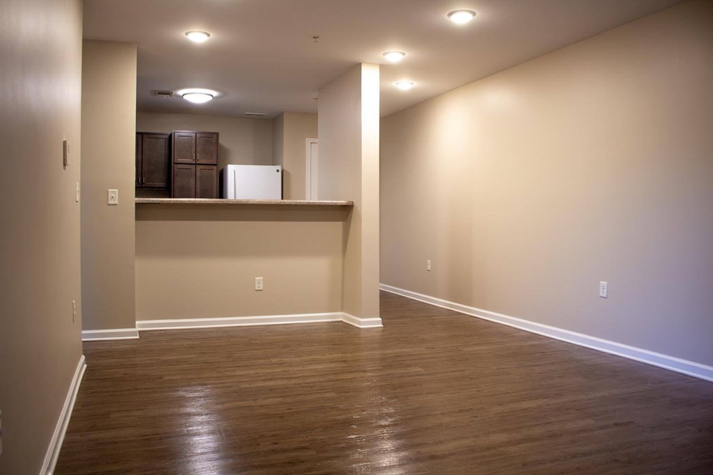 A room with wooden floors and a white refrigerator.