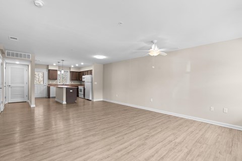 A spacious room with a ceiling fan and wooden flooring.