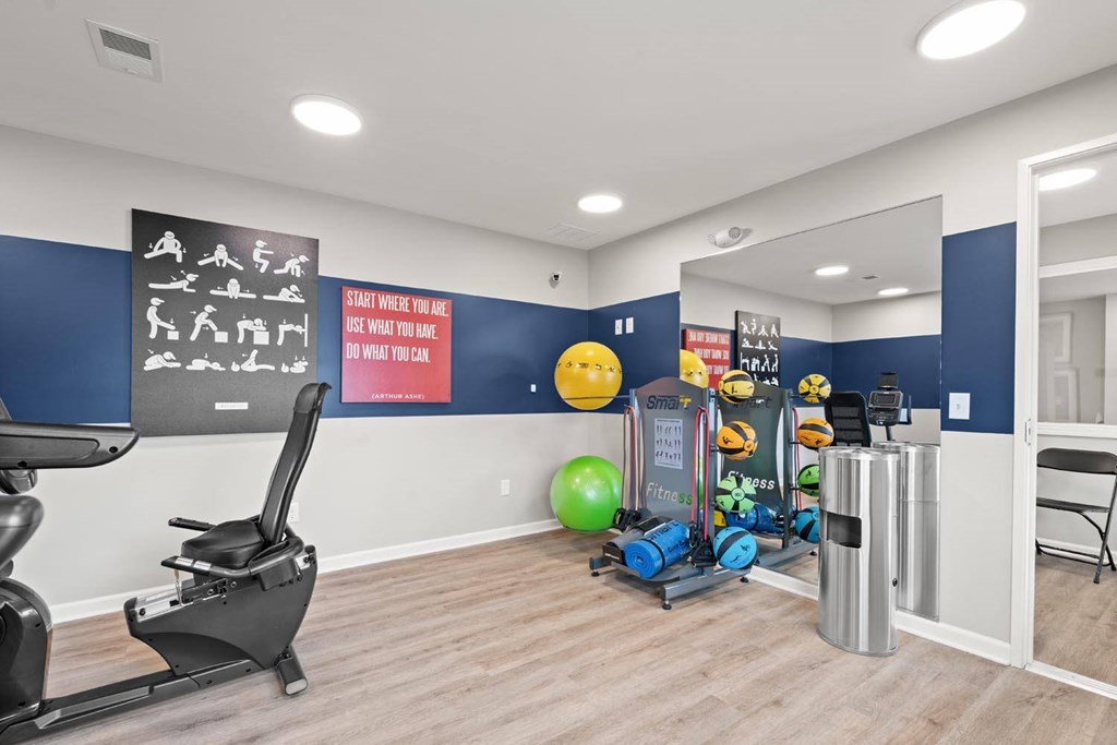 A gym room with a variety of exercise equipment.