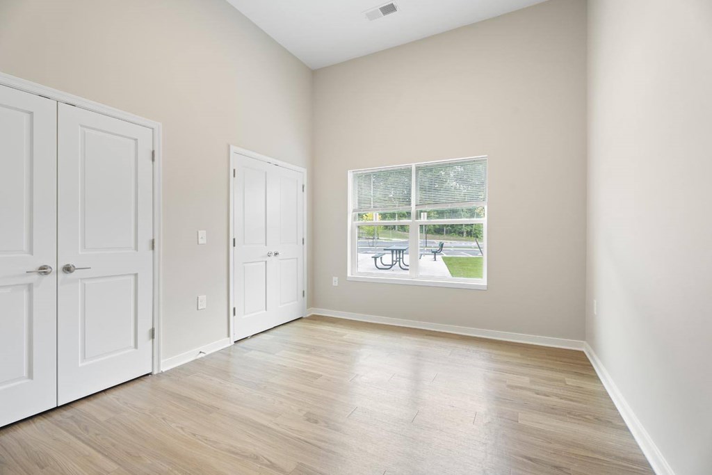 A room with two doors and a window showing a patio.