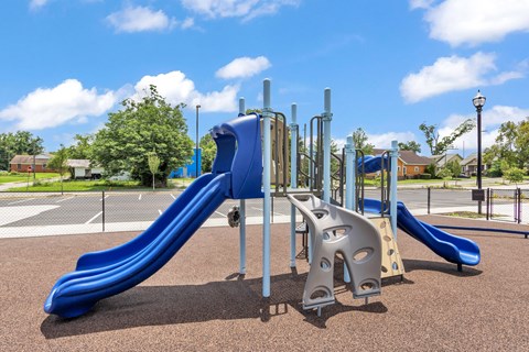 A playground with a blue slide and a climbing structure.