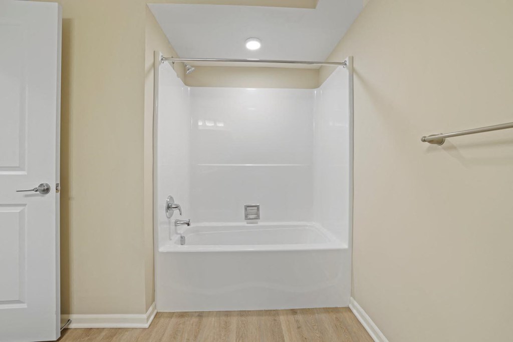 a white bathroom with a shower and a tub