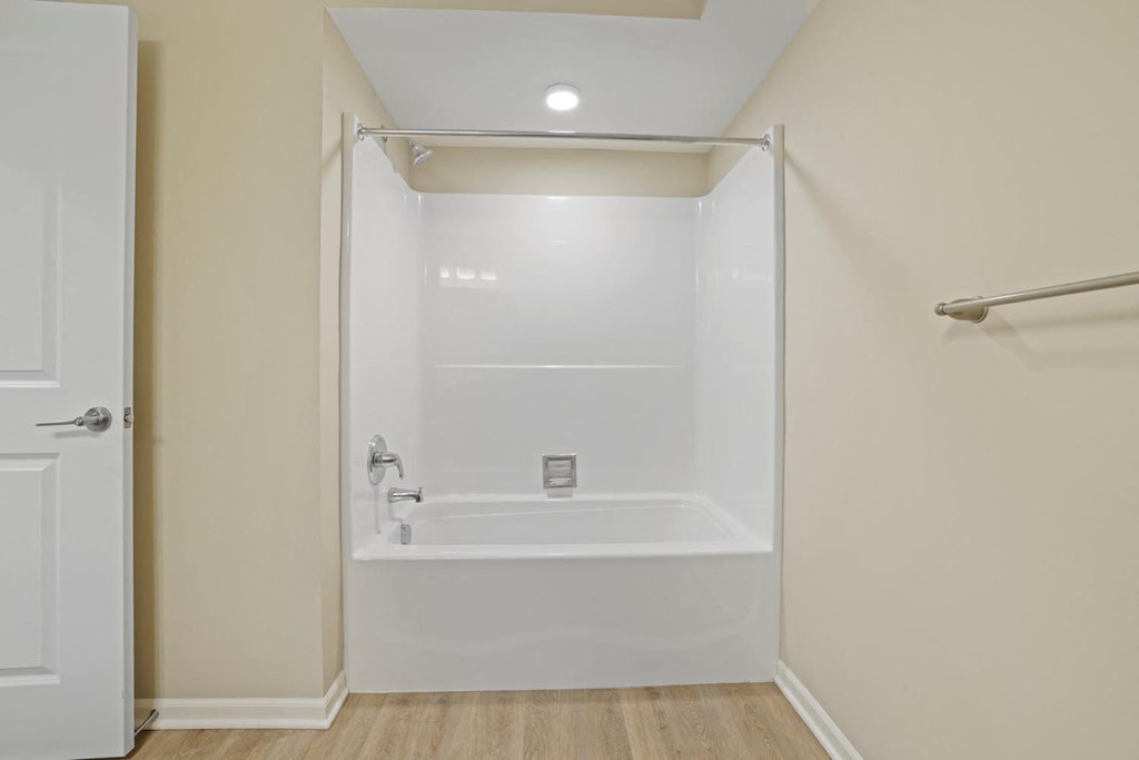 a white bathroom with a shower and a tub