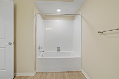 a white bathroom with a shower and a tub