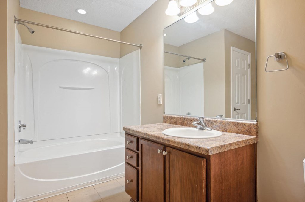 a bathroom with a sink and a shower and a mirror