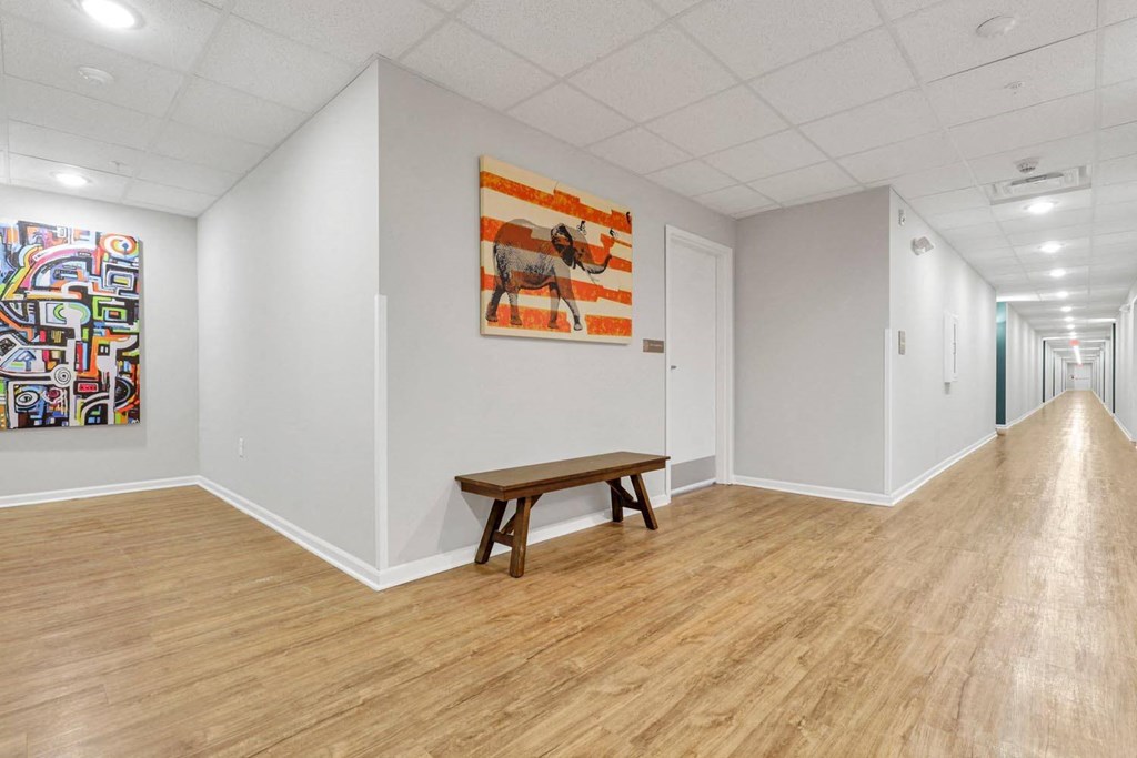 a room with a table and a painting on the wall and a hallway with a