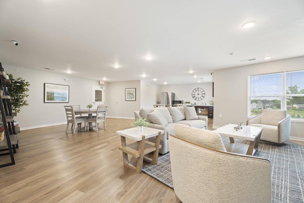 A living room with a couch, chairs, and a dining table.