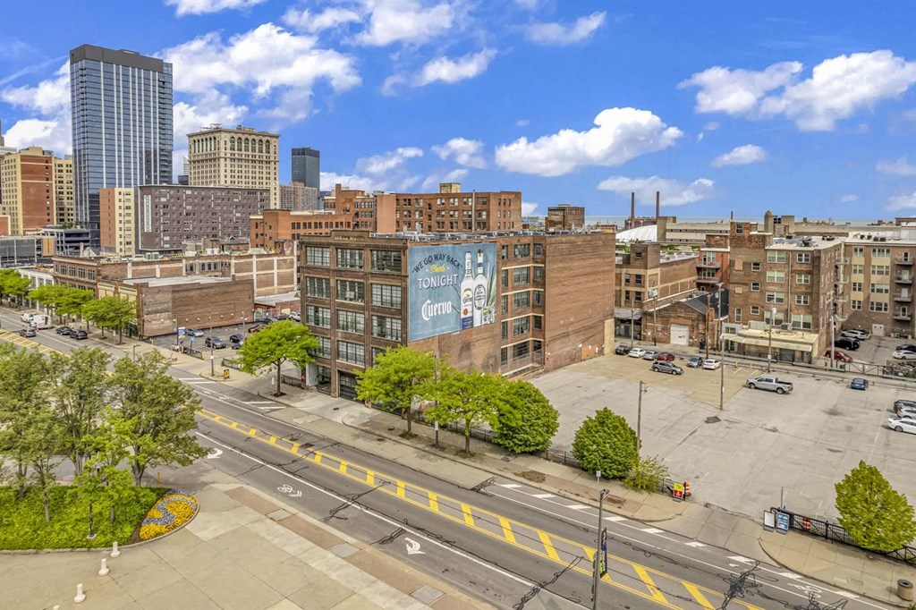 an aerial view of a city street with buildings in the background and a blue sky in the