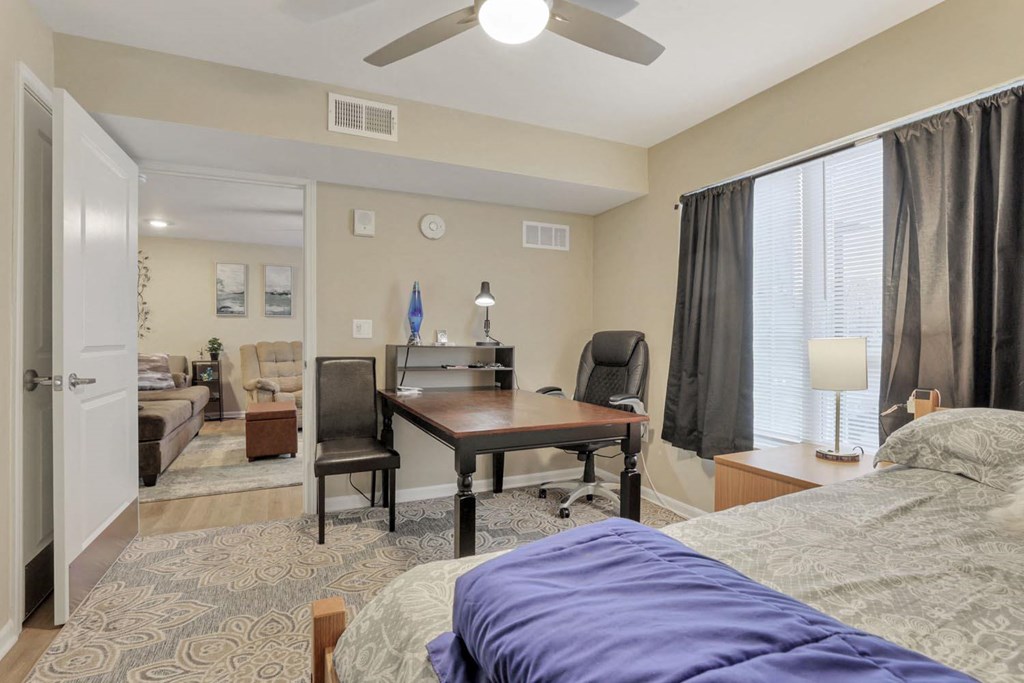 a bedroom with a bed and a desk