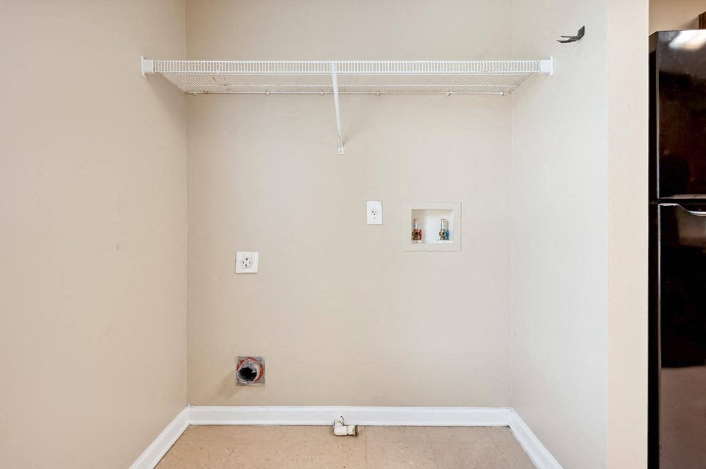 a room with a white wall and a refrigerator