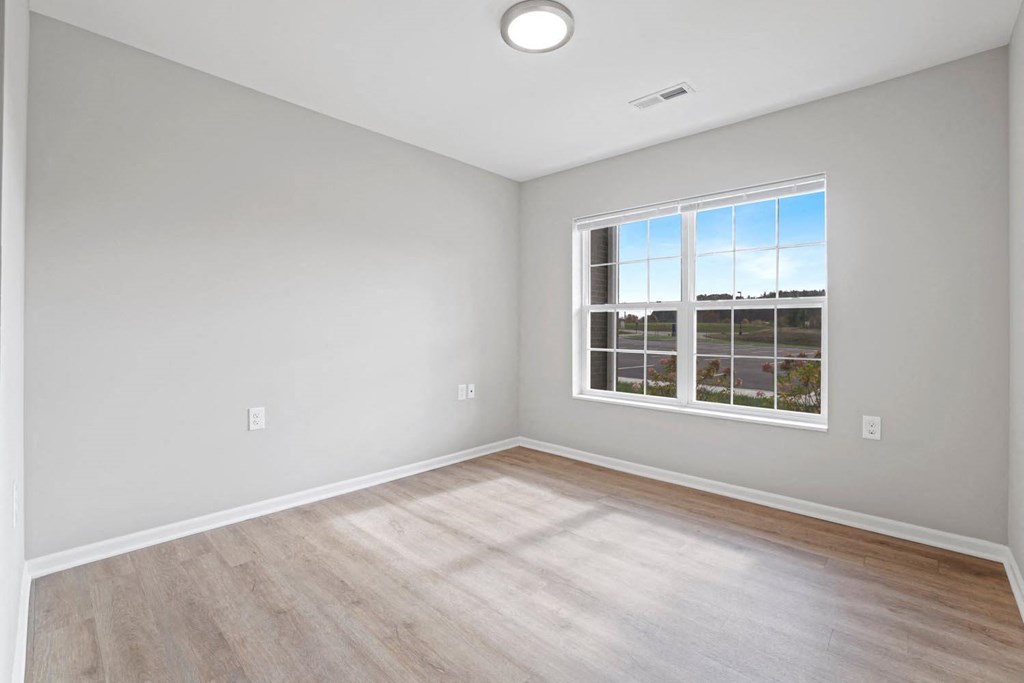 an empty room with wood floors and a window