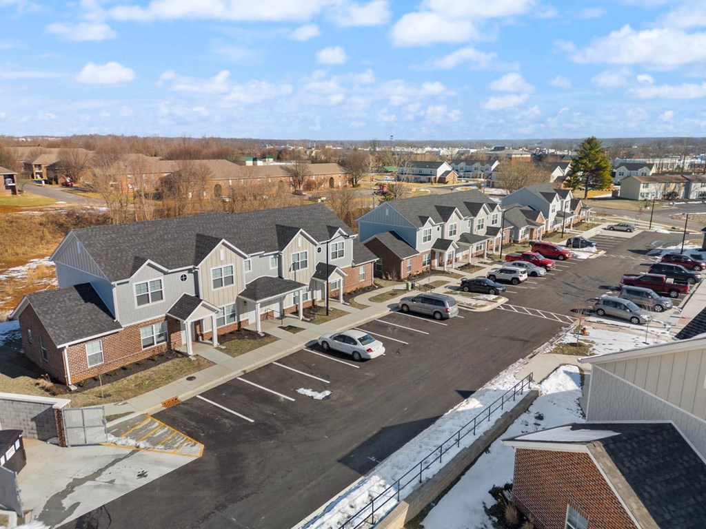 A parking lot with cars and apartment buildings in the background.