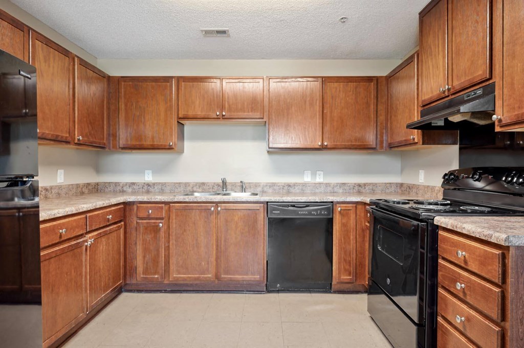 a large kitchen with wooden cabinets and black appliances