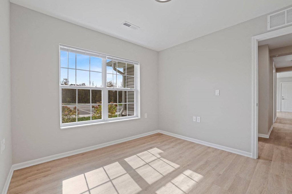 a living room with a large window and wooden floors