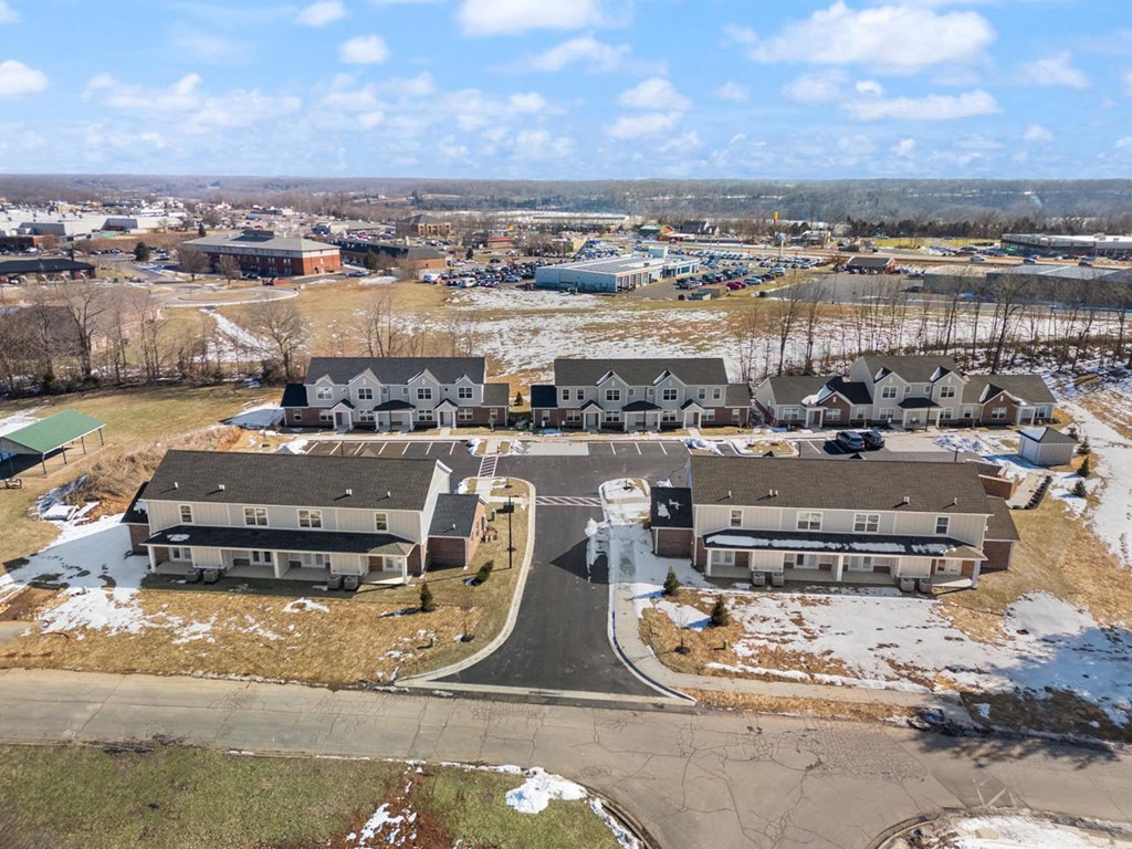 A large building complex with a central fountain in front of it.