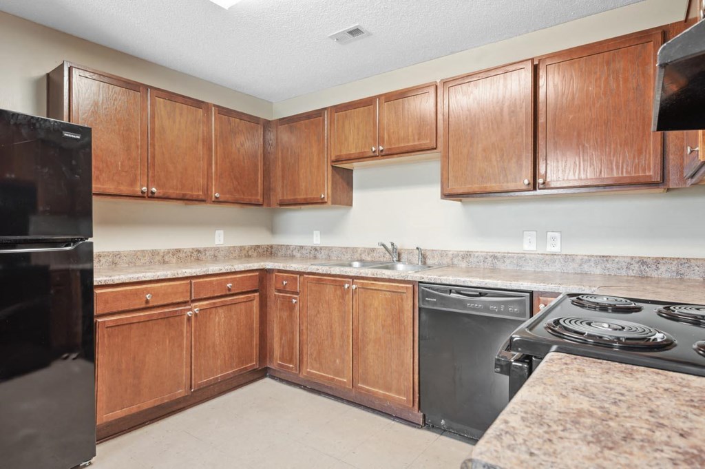 a kitchen with wooden cabinets and black appliances