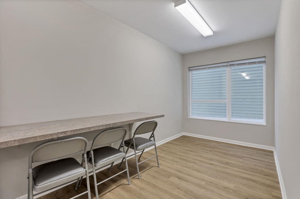 a dining room with a long table and chairs in front of a window