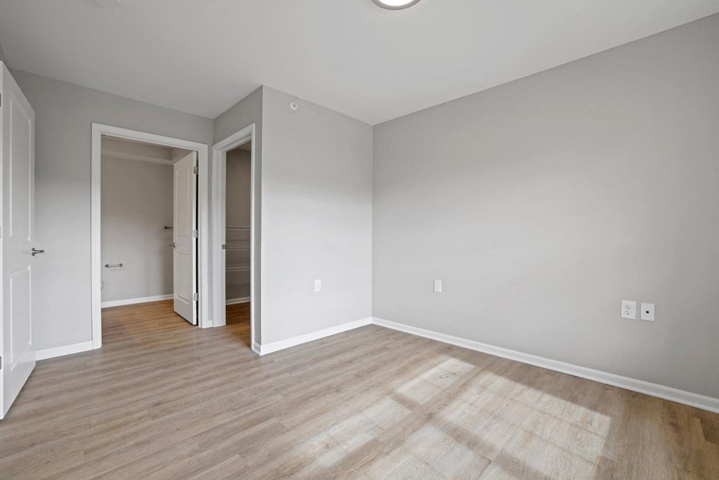 a living room with wood floors and a door to a hallway