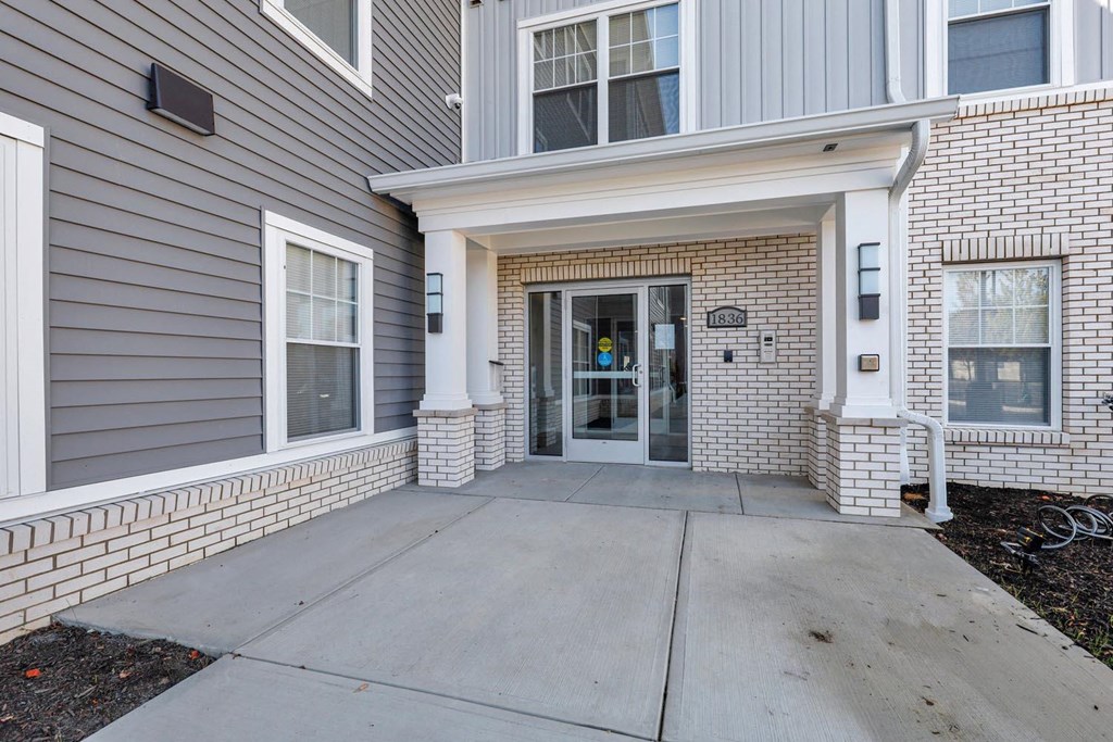 the front entrance of a building with a concrete sidewalk