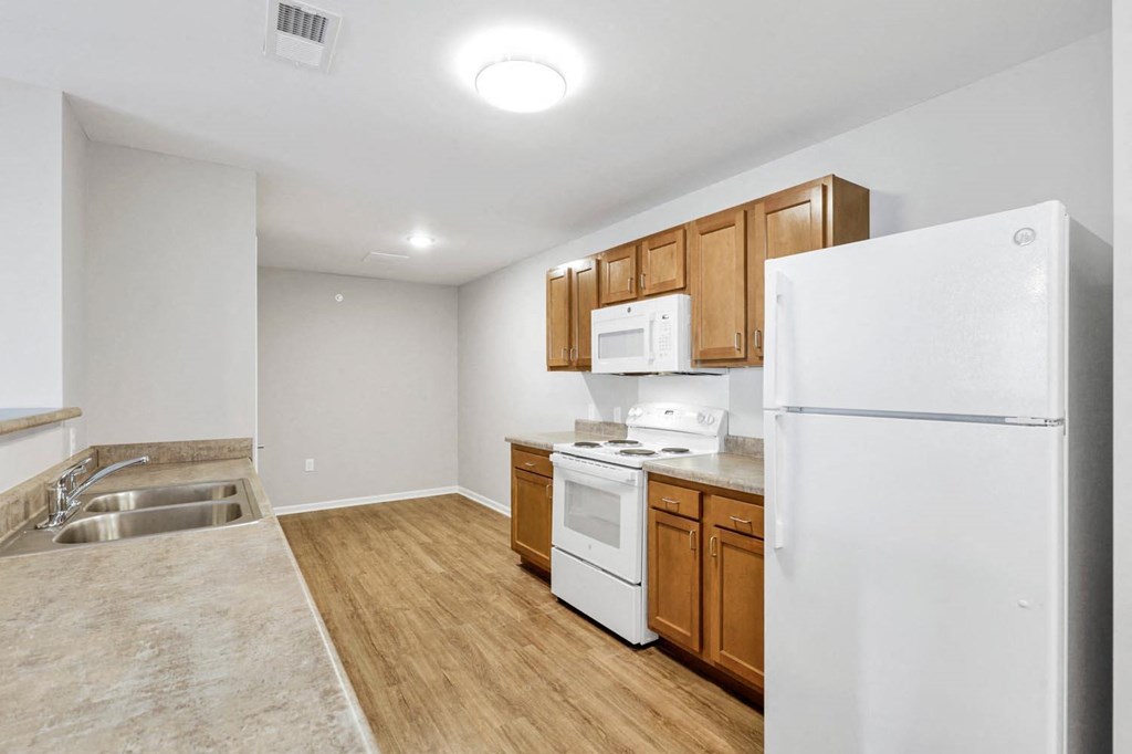 a kitchen with white appliances and wooden cabinets