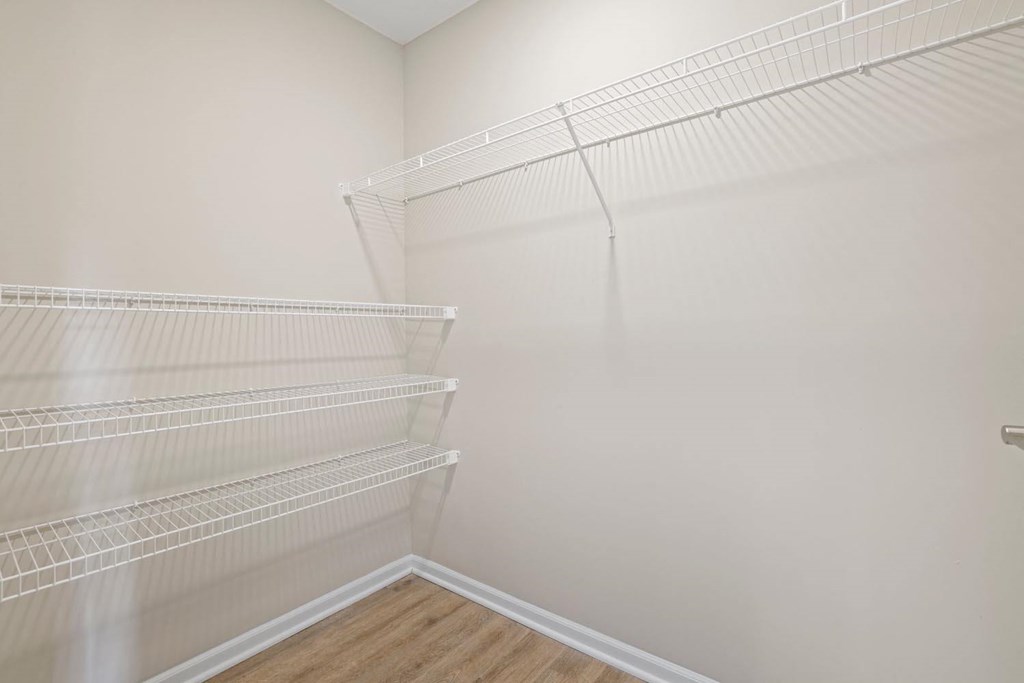 the closet in the bedroom of a home with white walls and