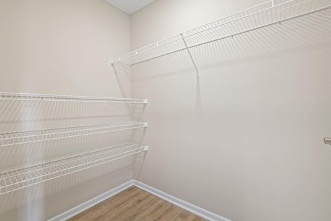 the closet in the bedroom of a home with white walls and