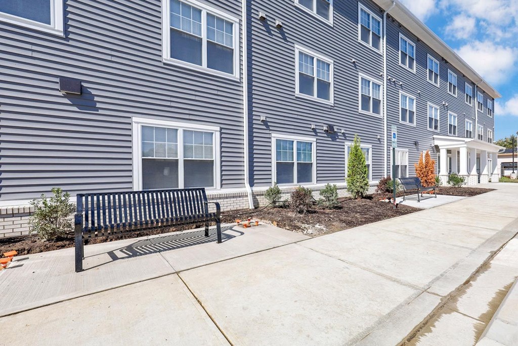 a bench in front of a building with a sidewalk