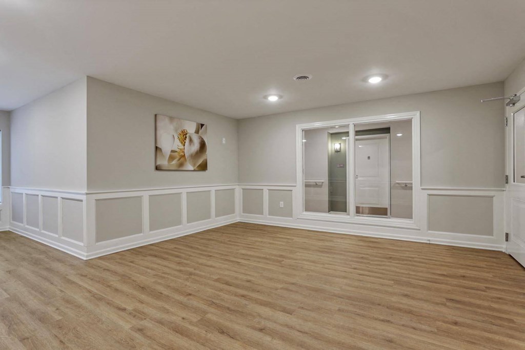 a living room with white walls and a mirror and a closet