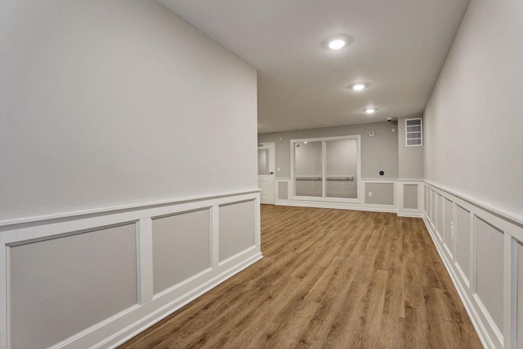 a living room with white walls and wood floors
