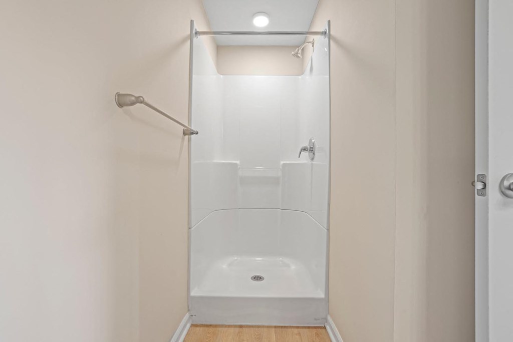 a white bathroom with a shower and a shower curtain