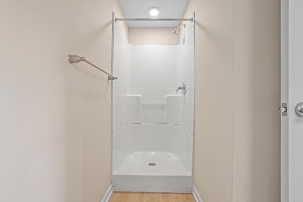 a white bathroom with a shower and a shower curtain