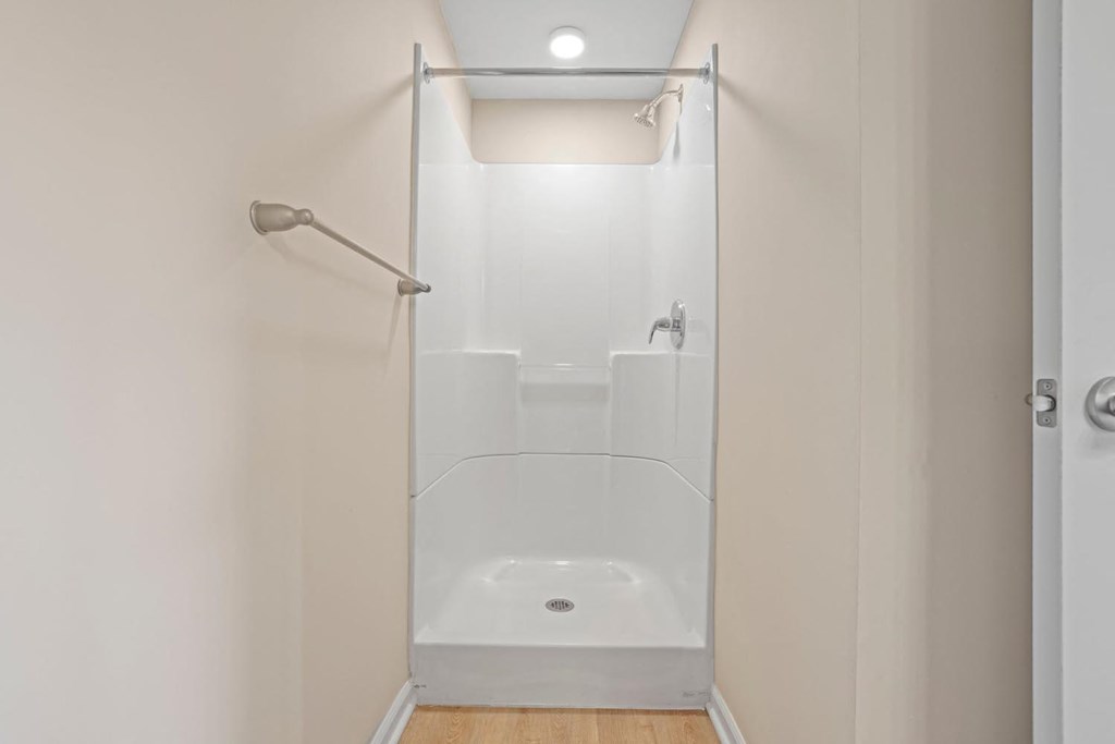 a white bathroom with a shower and a shower curtain