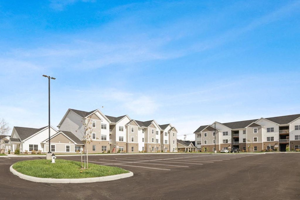 an empty parking lot in front of an apartment building
