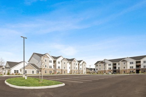 an empty parking lot in front of an apartment building