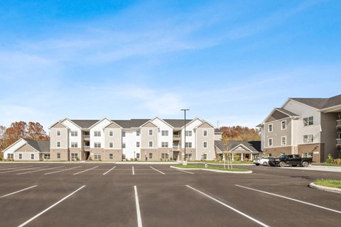 an empty parking lot in front of an apartment building