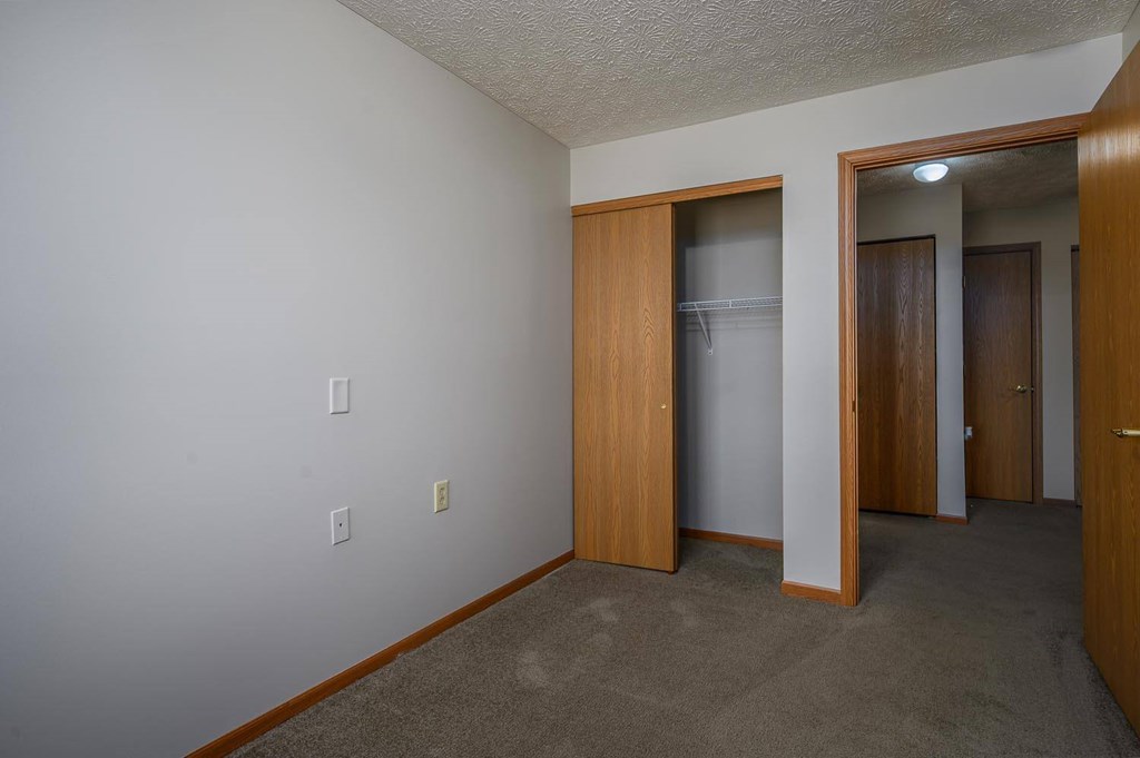 A room with a white wall and a brown door.