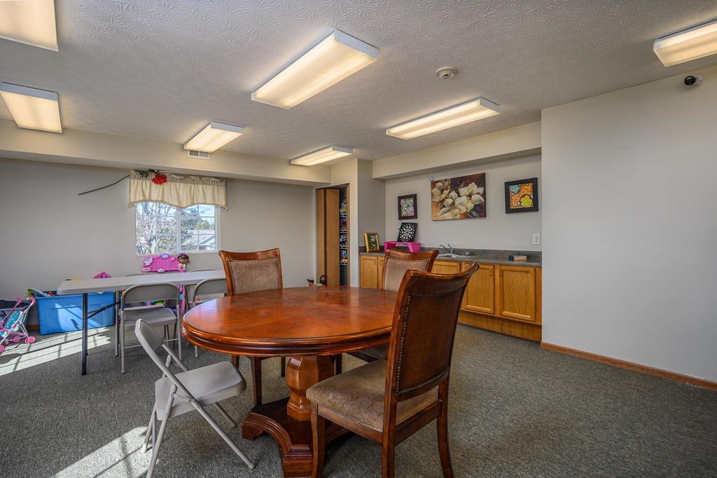 A dining room with a wooden table and chairs.