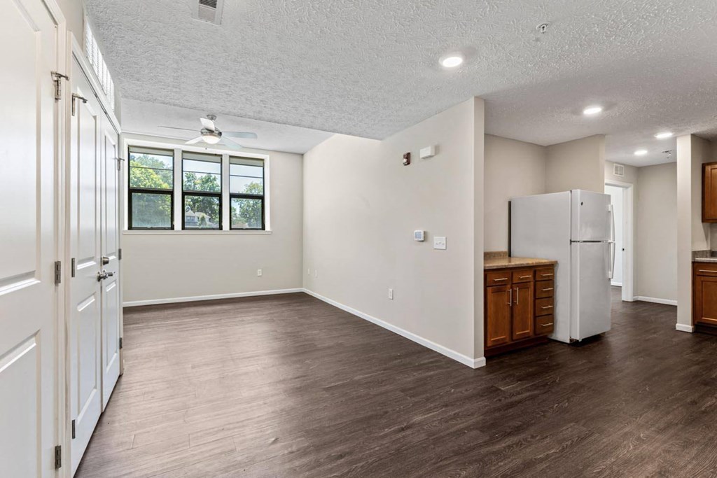 an empty kitchen and living room with a refrigerator