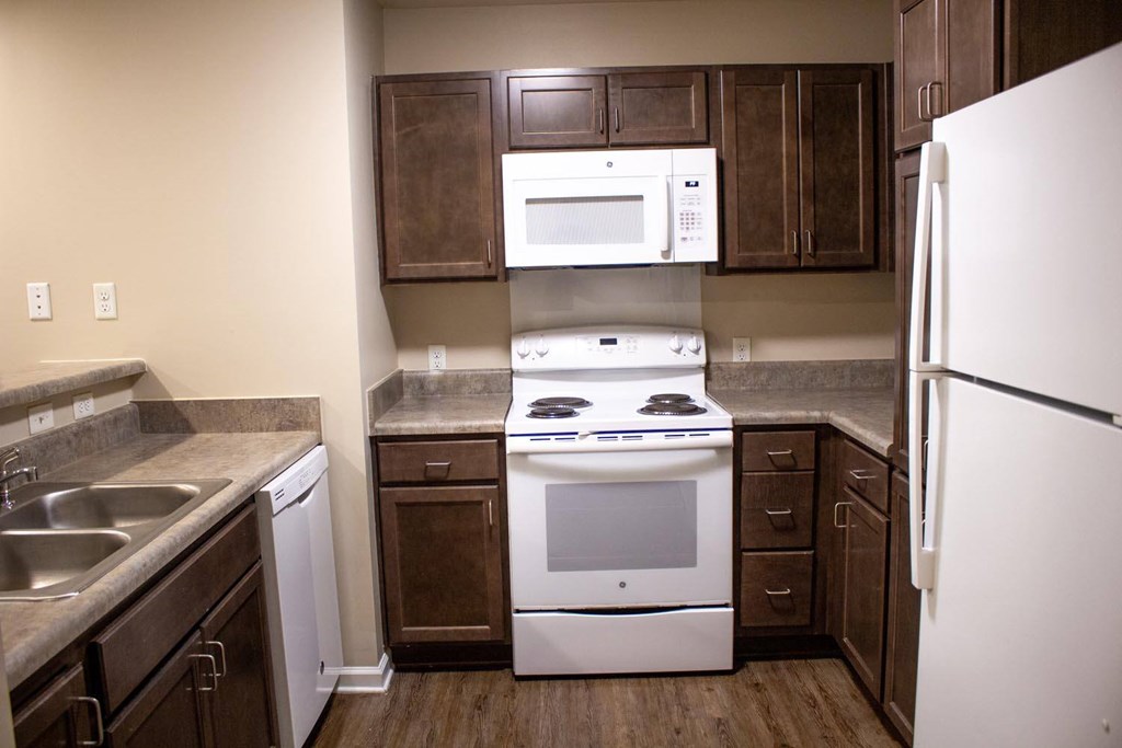 A kitchen with a white stove and a white refrigerator.