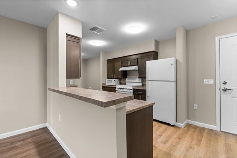 A kitchen with a white refrigerator and wooden countertops.