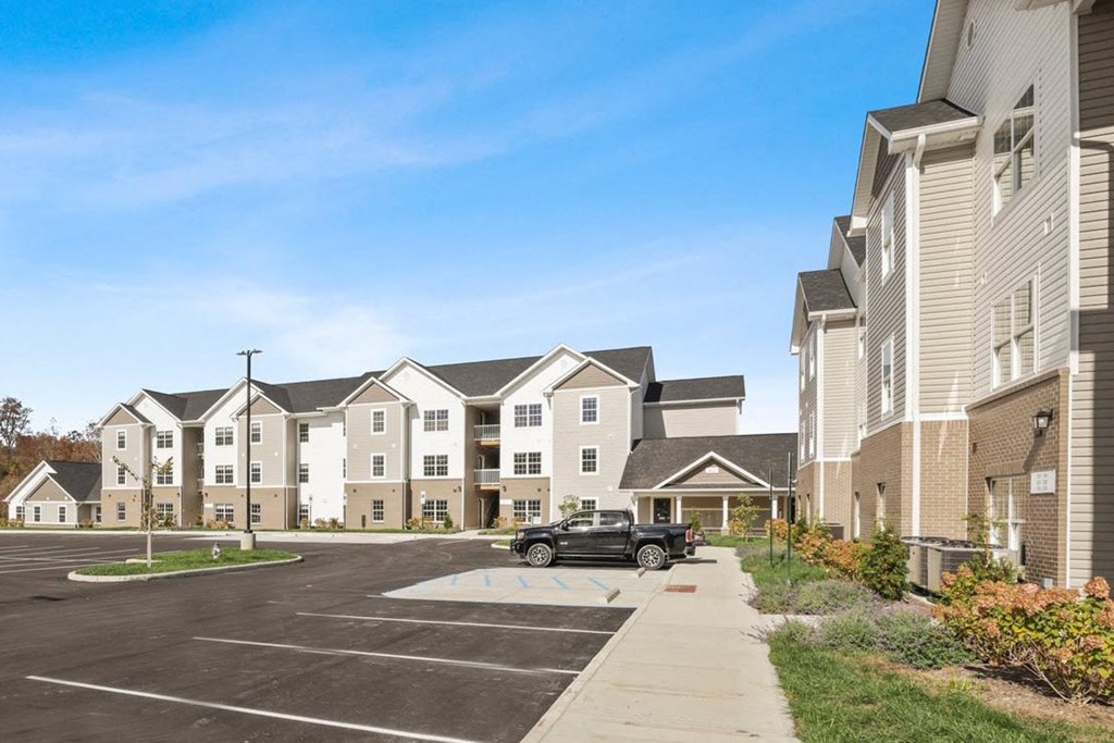 a car parked in a parking lot in front of an apartment building