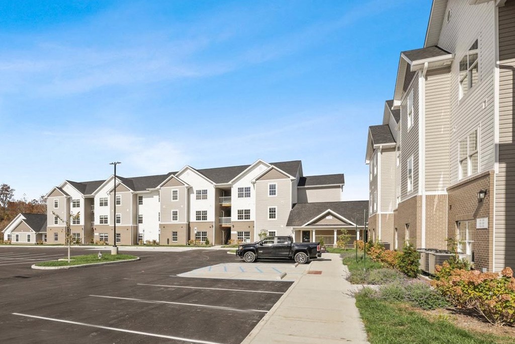a car parked in a parking lot in front of an apartment building
