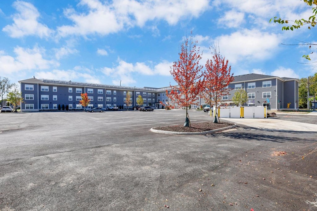 an empty parking lot in front of an apartment building