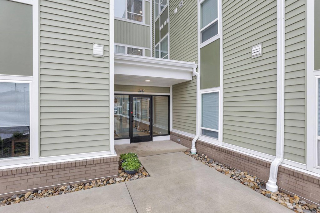 the entrance to an apartment building with a concrete walkway