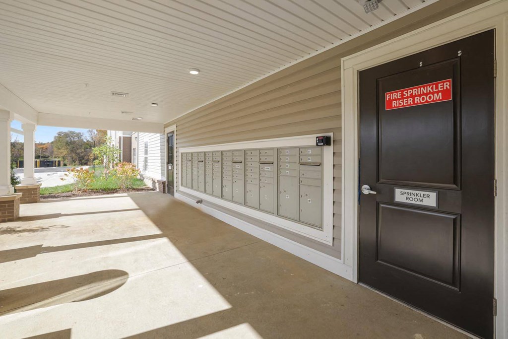 the front door of a building with mailboxes and a sign that reads post office