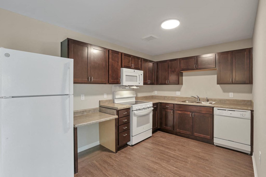 a kitchen with white appliances and wooden cabinets