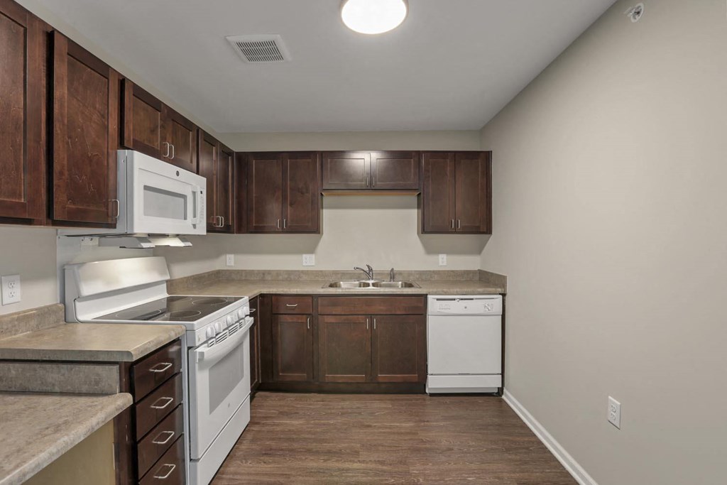 a kitchen with white appliances and wooden cabinets