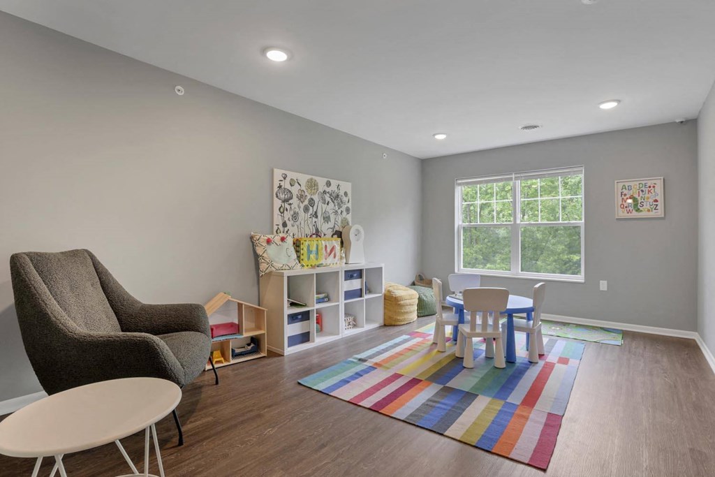 a play room with a table and chairs and a window