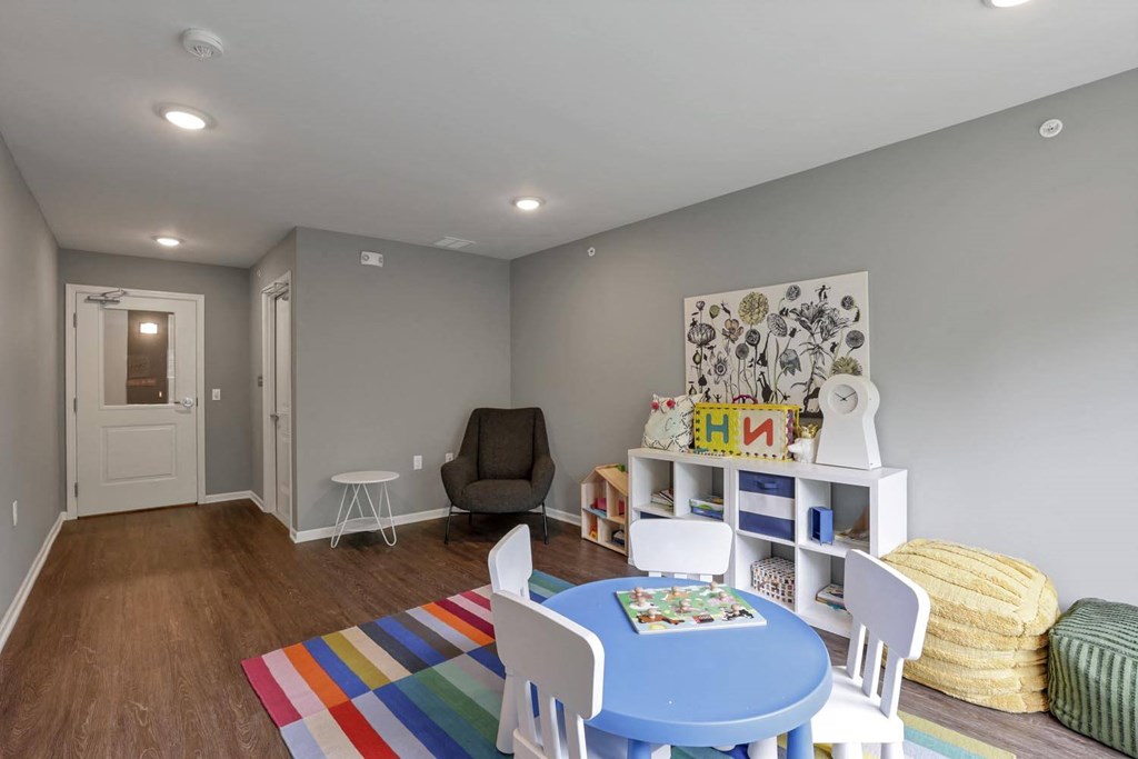 a play room with a table and chairs